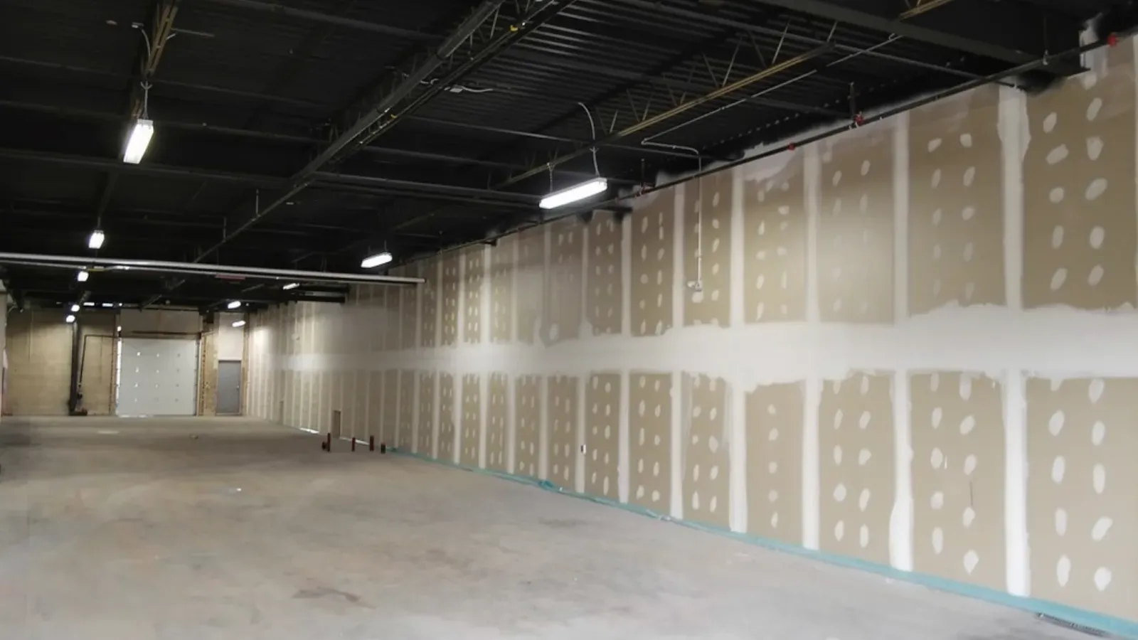 Fire-rated drywall demising walls taped from floor to deck in a commercial interior